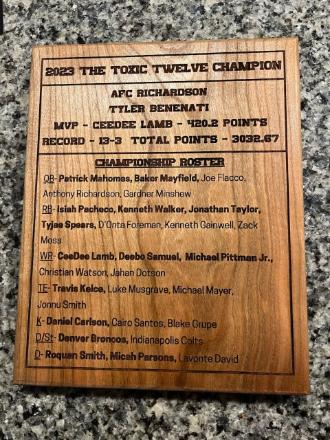 Wooden plaque with 2023 NFL championship statistics on a granite surface